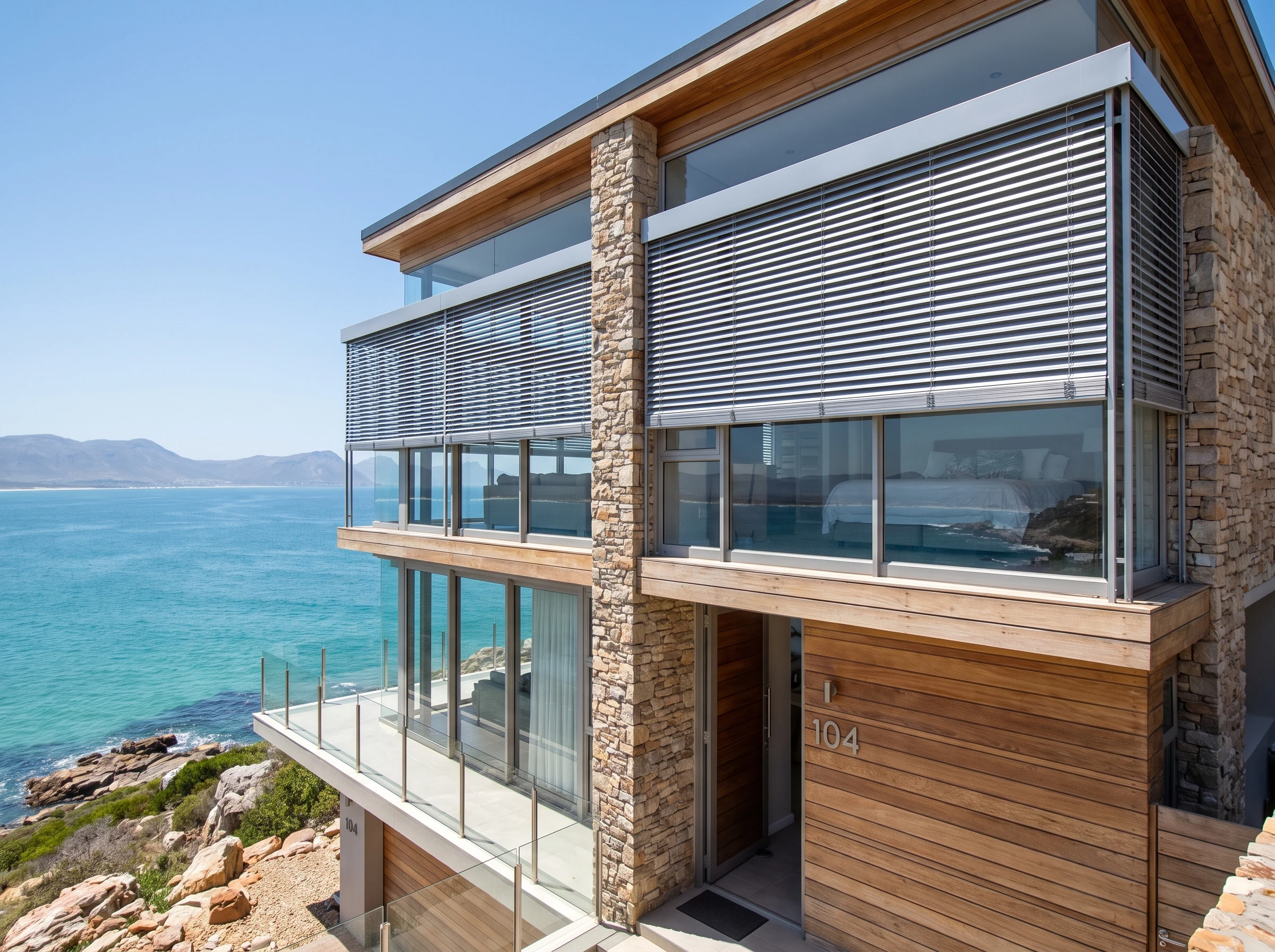 External aluminium venetian blinds on the upper-storey windows of a Mossel Bay home facing the ocean
